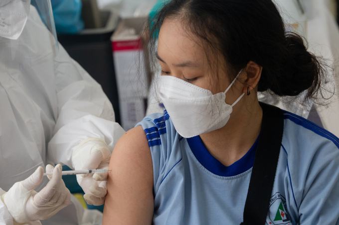 Nhân viên tiêm vắc xin cho học sinh tại trường học tại thành phố Hồ Chí Minh