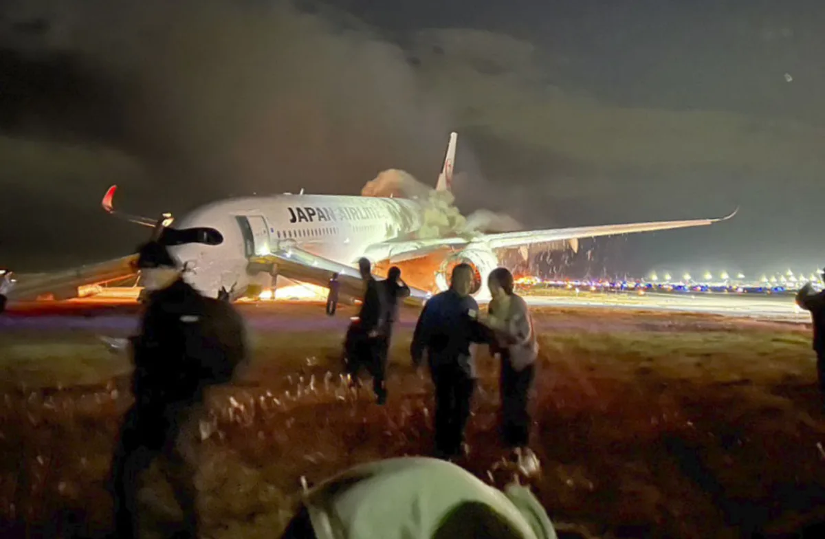 Hành khách thoát chạy khỏi máy bay tại sân bay Haneda, Tokyo hôm 2/1.